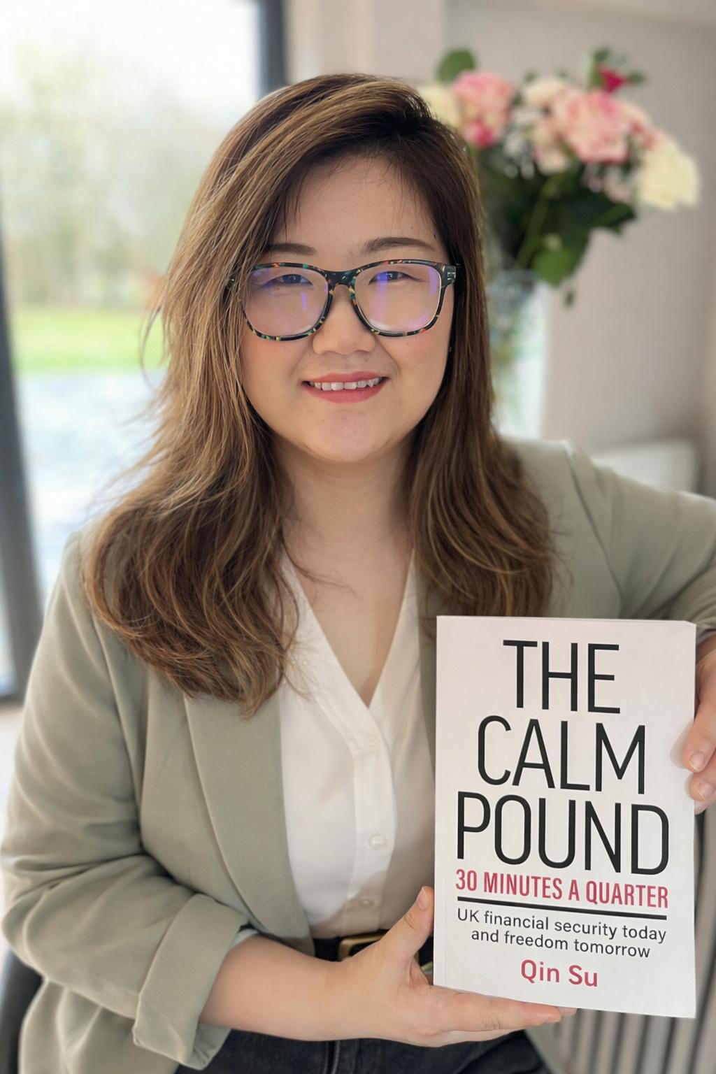 Qin Su, author and financial coach, smiling in professional headshot holding her book "the Calm Pound"